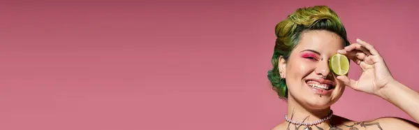 This joyful woman holds a lime slice to her eye, flaunting her vibrant style. — Stock Photo