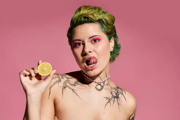 A young beautiful woman with vibrant hair shows her playful side while holding a lemon slice. — Stock Photo