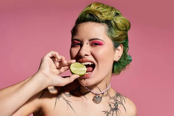 Confident young woman bites a lime, flaunting trendy makeup and style. — Stock Photo