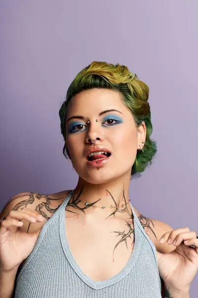 Stylische Frau mit buntem Haar und auffälligem Make-up posiert selbstbewusst vor pastellfarbenem Hintergrund. — Stockfoto