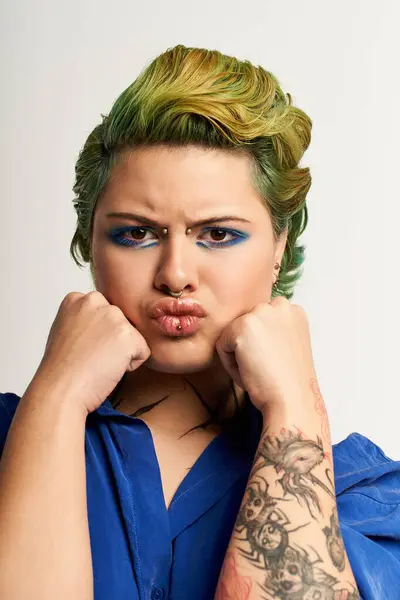 Jovem mulher em roupa elegante com maquiagem azul impressionante posa com confiança e charme. — Fotografia de Stock