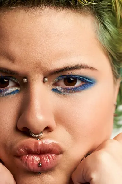 A confident young woman showcases her vibrant personality through striking makeup and style. — Stock Photo