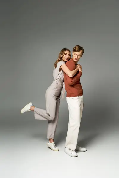 A fashionable couple posed playfully in a studio, highlighting their stylish spring outfits. — Stock Photo