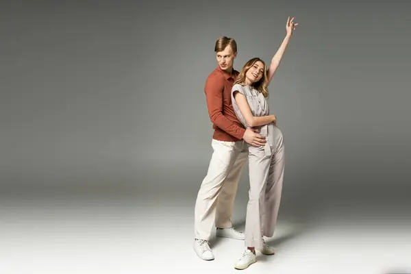 Young couple poses playfully in spring outfits, exuding confidence and fashion flair together. — Stock Photo