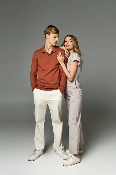 A fashionable young couple poses together in a modern studio, embracing spring vibes with style. — Stock Photo