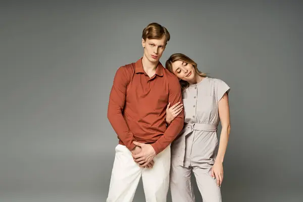 A young couple in trendy spring outfits poses together, radiating joy and connection in a studio. — Stock Photo