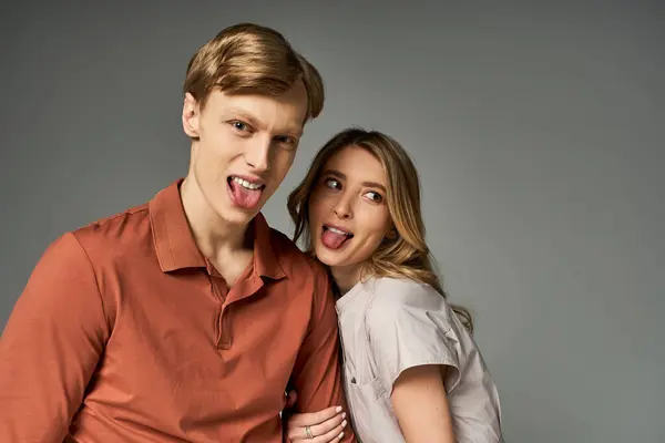 Young couple expresses their playful personalities in trendy spring outfits, smiling joyfully. — Stock Photo