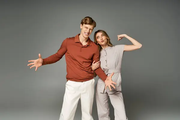 A fashionable young couple poses in trendy spring outfits, radiating joy and style in a studio. — Stock Photo