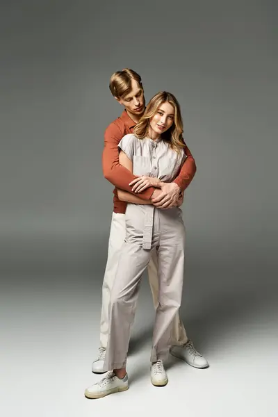 A fashionable young couple embraces in a studio, showcasing modern spring outfits and joy. — Stock Photo