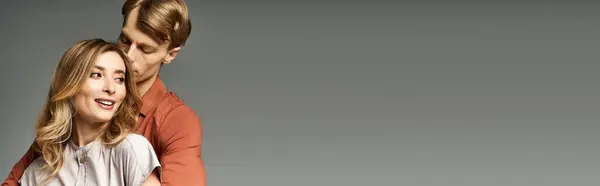 Pareja joven exhibe trajes de moda de primavera mientras comparte un momento alegre en el estudio, pancarta - foto de stock