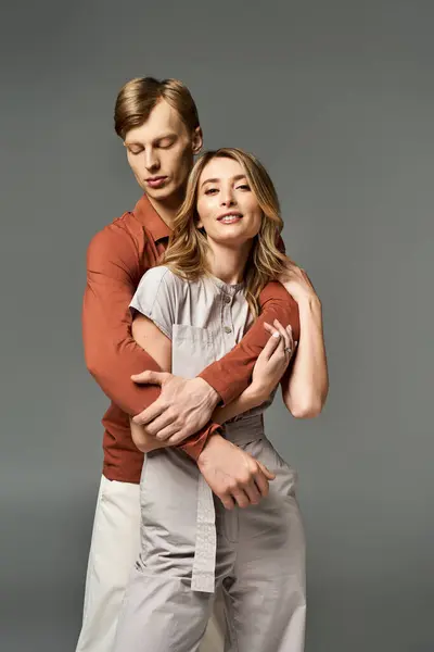 Young couple embraces affectionately while wearing trendy spring outfits in a styled studio. — Stock Photo
