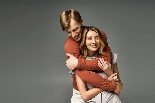 Couple enjoys a playful moment together, dressed in trendy spring outfits in a modern studio. — Stock Photo