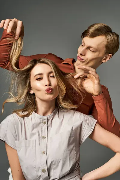 Una joven pareja muestra su espíritu juguetón mientras se viste con trajes de primavera, irradiando moda. - foto de stock