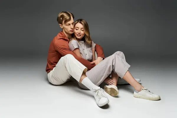 Stylish young couple relaxes together in spring outfits during a studio session. — Stock Photo