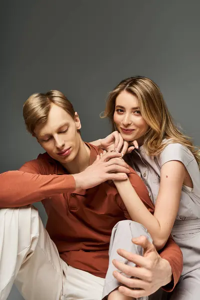 Una giovane coppia elegante posa giocosamente in uno studio, mostrando i loro abiti alla moda primaverile. — Foto stock