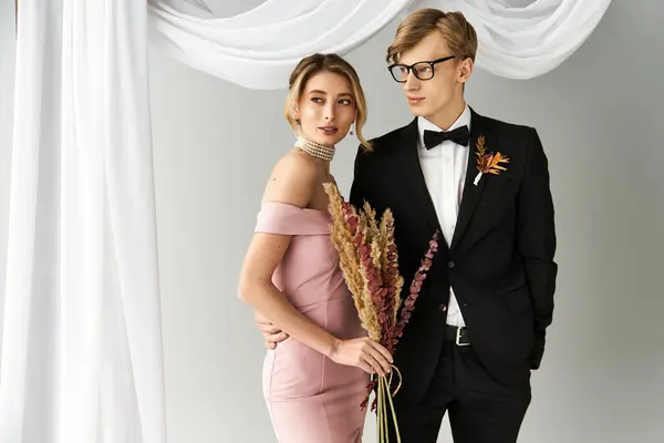 A young couple embraces in springtime, showcasing love and joy with elegant attire and flowers. — Stock Photo