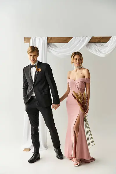 A young couple stands hand in hand, radiant in spring wedding attire, surrounded by elegance. — Stock Photo