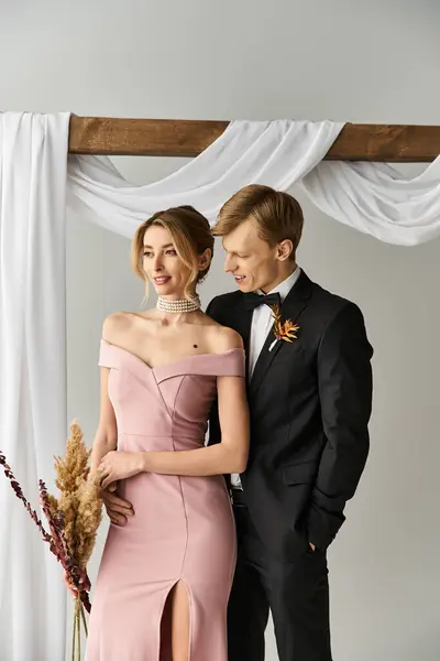 A young couple radiates love in their spring wedding, with the bride in a pink dress and groom. — Stock Photo
