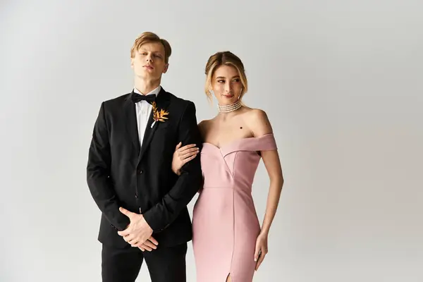 Una alegre pareja joven posa juntos, mostrando un impresionante vestido de novia rosa y un traje elegante. - foto de stock