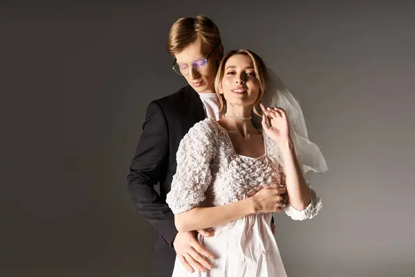 A joyful young couple shares a moment of love during their spring wedding, embracing tenderly. — Stock Photo