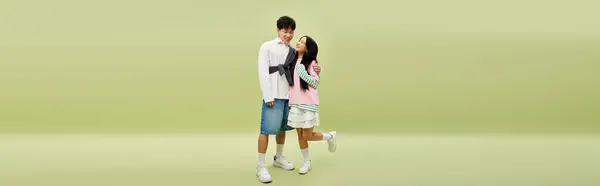 A stylish couple embraces joyfully, showcasing their playful love in a vibrant setting. — Stock Photo