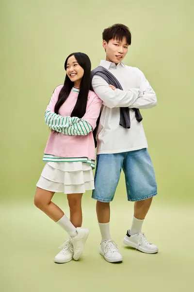 A fashionable couple stands together playfully, embodying romance and youthfulness in style. — Stock Photo