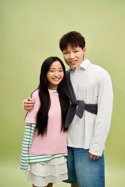 In a lively environment, a lovely couple embraces, showcasing fashionable outfits and happiness. — Stock Photo