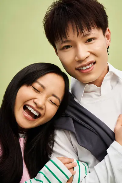 Una pareja se abraza alegremente, mostrando su estilo de moda y profundo afecto el uno por el otro. - foto de stock