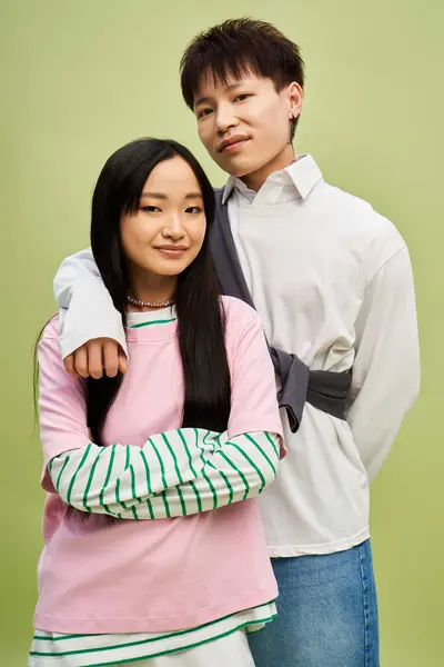 A stylish couple stands confidently together against a vibrant backdrop. — Stock Photo