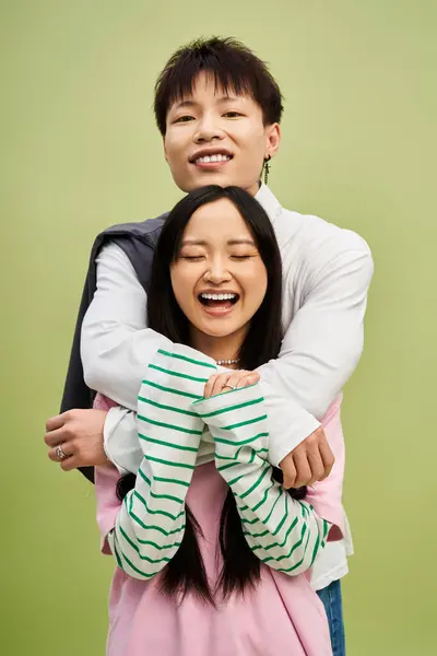 A charming couple with joyful expressions showcases love and style, framed by a colorful setting. — Stock Photo