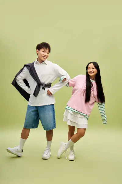 A cheerful couple poses playfully in trendy outfits, radiating romance and joy. — Stock Photo