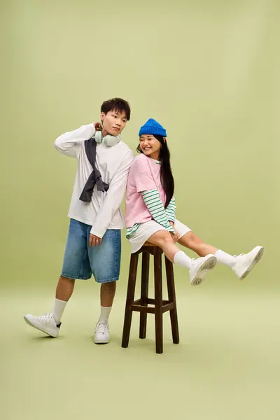 A fashionable couple shares a joyful and playful moment in a chic, colorful environment. — Stock Photo