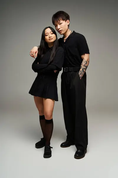 A couple exudes romance in chic black attire in a stylish, minimal indoor space. — Stock Photo