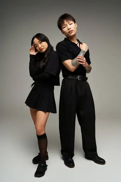 Un couple à la mode se tient étroitement ensemble, incarnant la romance et la confiance dans une tenue élégante. — Photo de stock