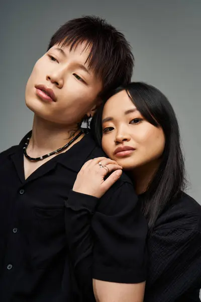 A stylish couple embraces, showcasing their love amidst a soft backdrop. — Stock Photo