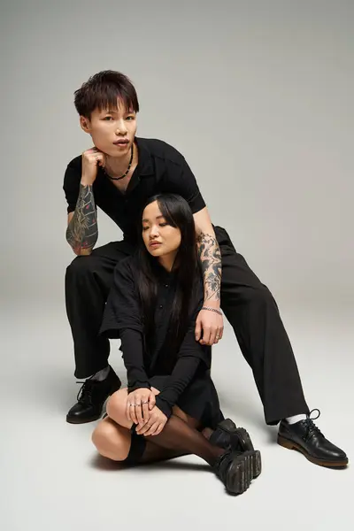 A lovely couple exuding romance and fashion sits together, showcasing their unique style and bond. — Stock Photo