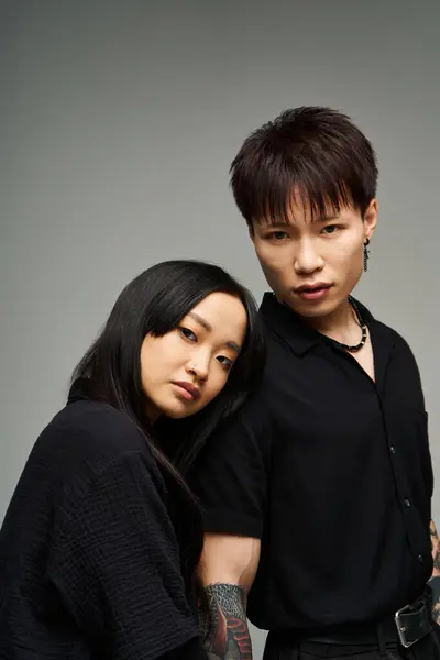A lovely couple poses closely together in a chic studio, showcasing fashionable outfits and love. — Stock Photo