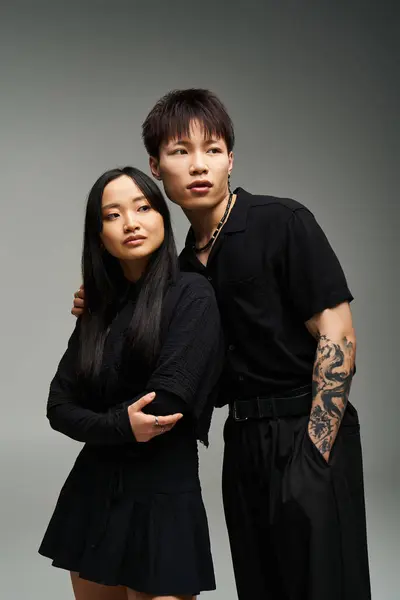 A stylish couple stands closely together, reflecting love and connection, dressed in chic outfits. — Stock Photo