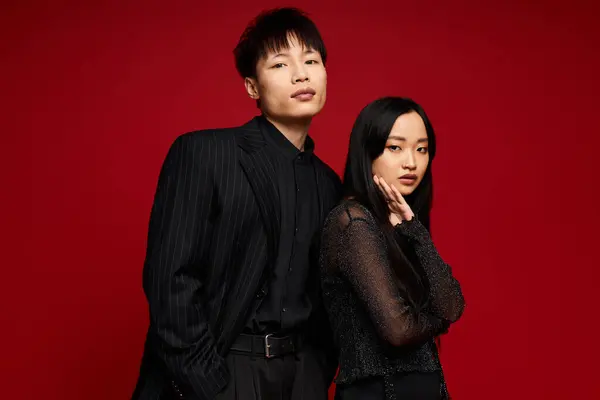 A fashionable couple stands confidently together, radiating love and style in a striking setting. — Stock Photo