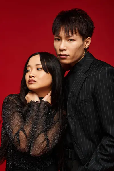 A stylish couple in elegant black shares a close, intimate moment together. — Stock Photo