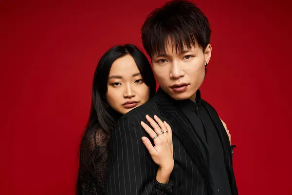 A fashionable couple stands closely together, showcasing deep affection in a striking setting. — Stock Photo