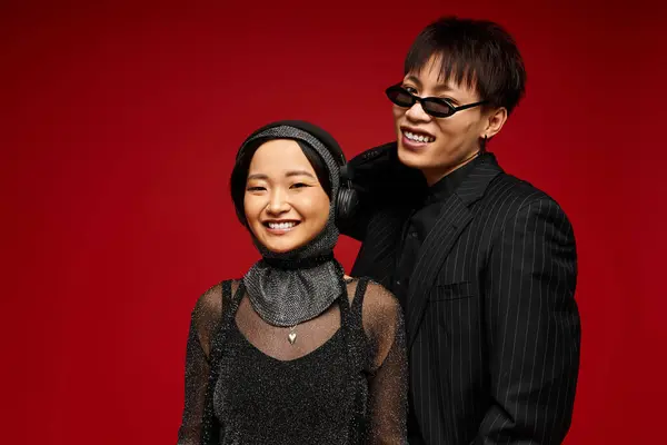 An elegant couple joyfully stands together, glowing with love against a bold red backdrop. — Stock Photo