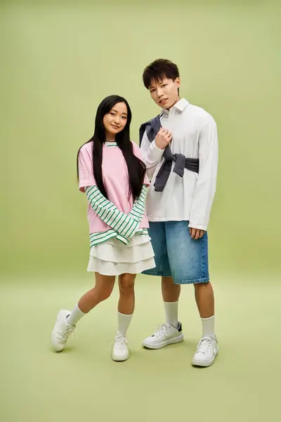 A stylish couple poses closely, flaunting trendy outfits and joyful smiles in a relaxed setting. — Stock Photo