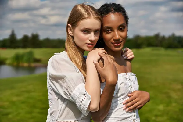 Two women share a warm embrace in lush greenery, highlighting their deep love and connection. — Stock Photo