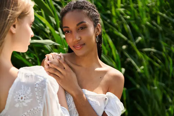 Jovens mulheres expressam amor e conexão enquanto desfrutam da natureza em um ambiente verde vibrante — Fotografia de Stock