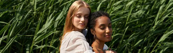 Two young women embrace lovingly in a vibrant field, radiating joy and affection together. — Stock Photo