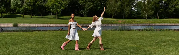 Two beautiful young women hold hands while enjoying a sunny day in the park, expressing love. — Stock Photo