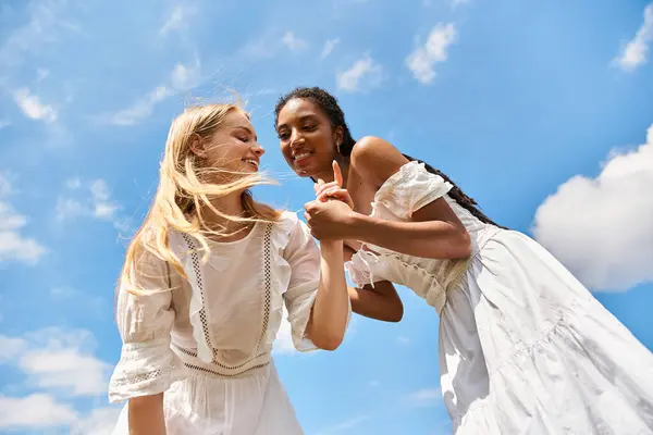 Two beautiful women playfully hold hands while laughing and enjoying each others company outdoors. — Stock Photo