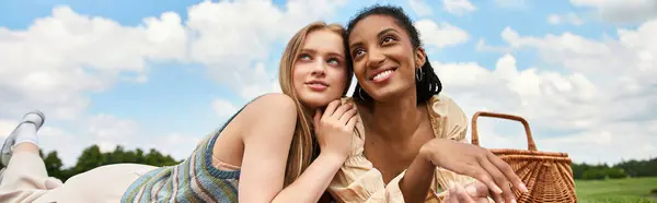Two young women share laughter and affection while relaxing on a sunny afternoon in nature. — Stock Photo