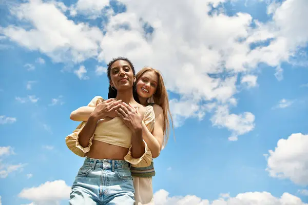 A lovely lesbian couple enjoys laughter and affection outdoors under a blue sky. — Stock Photo